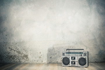 Retro outdated portable stereo boombox radio cassette recorder from 80s front concrete wall...