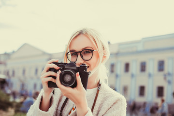 Beauty woman using vintage camera, make photo in the street, outdoor hipster portrait 