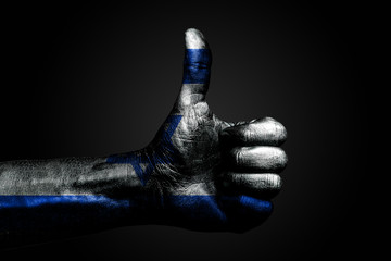 A hand with a drawn Israel flag shows a finger up sign, a symbol of success, readiness, a task done on a dark background.