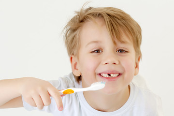 A little boy is brushing his teeth with a toothbrush.