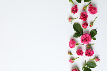 Flat lay composition with roses and petals on white background, space for text