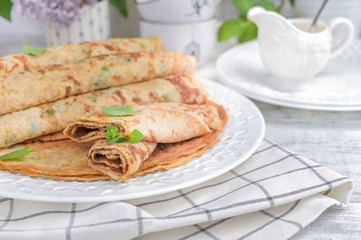 Pancakes with dill and white sauce on a light background. top view.