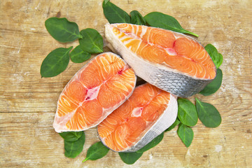 Fresh raw salmon fish steaks on wooden background