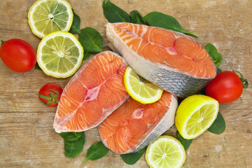 Fresh raw salmon fish steaks on wooden background