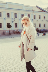 Beauty woman using vintage camera, make photo in the street, outdoor hipster portrait 