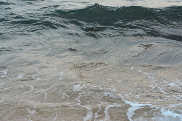 Beautiful soft waves of Blue Ocean with Sandy Beach Background close up. Sea sand wallpaper