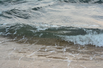 Beautiful soft waves of Blue Ocean with Sandy Beach Background close up. Sea sand wallpaper