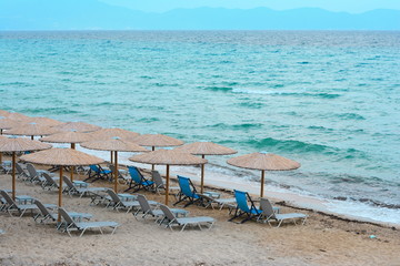 Fototapeta na wymiar Beach umbrellas woven from cane on a sandy beach
