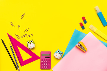 children's stationery for school.Kids flat lay. back to school.top view. copy space for text.ruler,scissors,colored paper,pens,calculator, microscope on a yellow background.bright study supplies