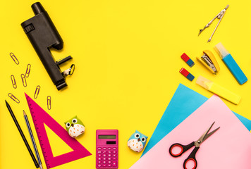 children's stationery for school.Kids flat lay. back to school.top view. copy space for text.ruler,scissors,colored paper,pens,calculator, microscope on a yellow background.bright study supplies