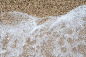 Beautiful soft waves of Blue Ocean with Sandy Beach Background close up. Sea sand wallpaper