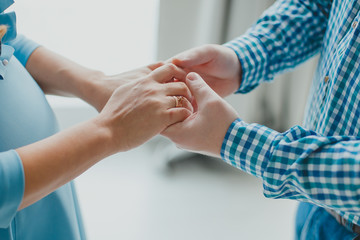 Wife and husband hold hands.