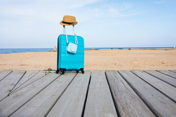 Close-up of blue luggage in front of the sea