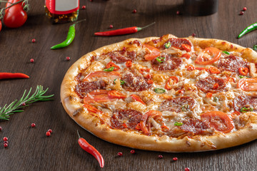 Spicy pizza Diablo near peppers close-up.