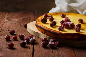 Handmade Fruit Pie on a baking sheet and a cup with hot tea or coffee on a wooden background. The concept of homemade culinary skills.