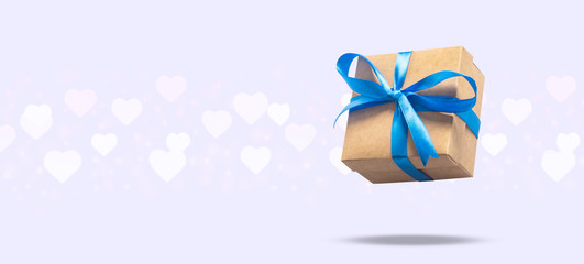 Flying gift box on a light background with heart shaped bokeh. Holiday concept, gift, sale, wedding and birthday. Banner