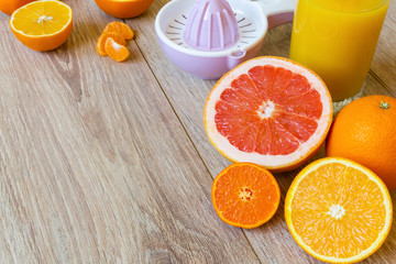 Obraz na płótnie Canvas various citrus fruits, reamer and juice