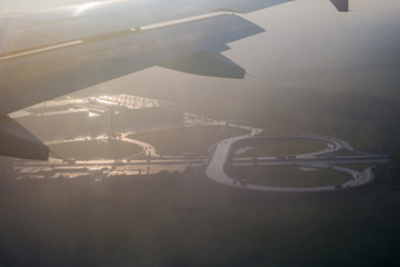 Road junction under the wing of the aircraft in the last rays