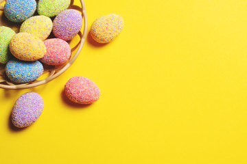 Fototapeta na wymiar Colorful easter eggs in basket on yellow background.