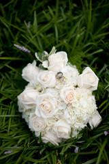 bouquet of white roses with wedding rings