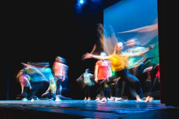 Fototapeta Group of dancer in colored clothes dancing on the stage in long exposure obraz
