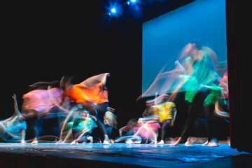 Gordijnen Group of dancer in colored clothes dancing on the stage in long exposure © ledmark31
