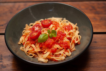 Plato de cerámica con pasta de jitomate y guarnición fresca