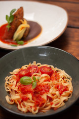 Plato de cerámica con pasta de jitomate y guarnición fresca