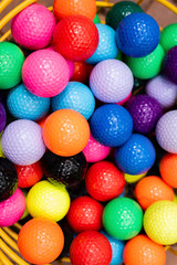 Colorful golf balls in wire bucket for putt-putt or driving range