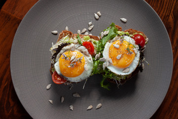 Desayuno con huevos estrellados sobre pan tostado integral con germen de trigo y semillas