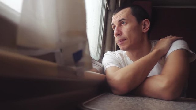 man sad bored riding a train railway looks out the window. traveler concept train railroad journey travel. slow motion video. beautiful from window lifestyle of a moving train railway trip Russia