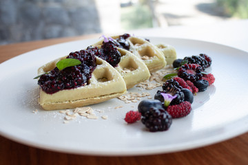 Desayuno waffles con mermelada y frutos rojos