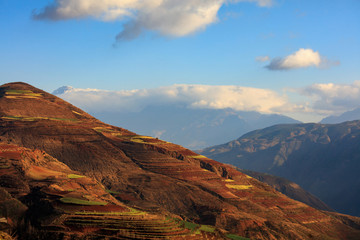 Dongchuan Red Soil, Colored Earth Terraces - Red Soil, Green Grass, Layered Terraces in Yunnan Province, China. Chinese Countryside, Agriculture, Exotic Unique Landscape. Farmland, Agriculture