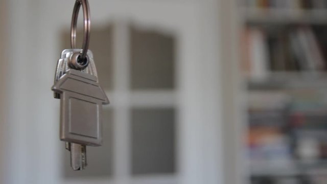 House keys with keychain rotate in the background