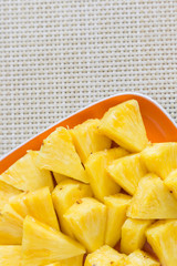 Chopped pineapple on a orange color plate