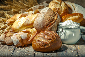 Assortment of baked bread on wooden table background