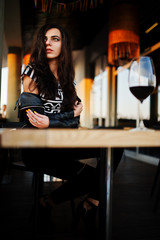 Young curly woman enjoying  her wine in a bar.