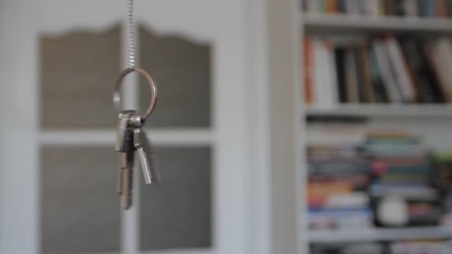 House keys with keychain rotate in the background