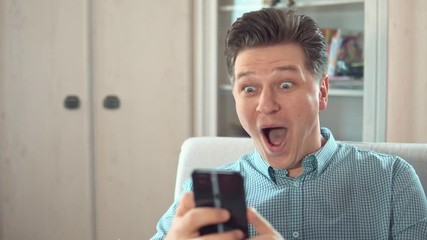 Young attractive man rejoices in unexpected winnings and success