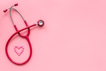 Fototapeta premium stethoscope and heart for diagnostic and cure of heart disease on pink background top view mockup