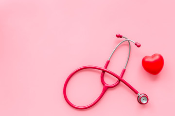stethoscope and heart for diagnostic and cure of heart disease on pink background top view mockup