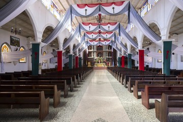 Interior of old Catholic Church with Prayer Booths and Religious Symbols in San Juan Village on shores of Lake Atitlan in Guatemala Highlands - obrazy, fototapety, plakaty