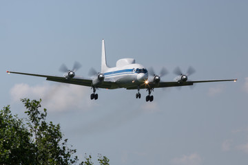 screw russian plane landing with smoke/  old screw aircraft in the sky, chassis released/  military aircraft with radar