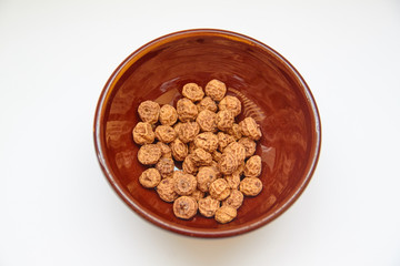 Sight a lot of tigernuts in a bowl of mud on a white background. The Spanish tigernut is called chufa