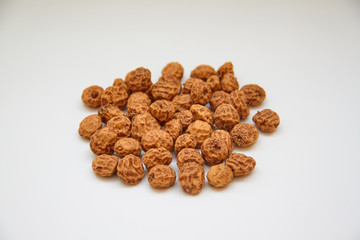 Side view of a pile of insulated tigernuts on a white background. The Spanish tigernut is called...