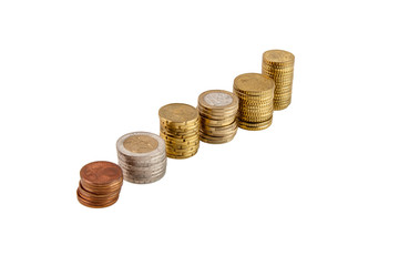 Coins of different countries are stacked in the distance hardly in stacks of different heights on a white isolated background