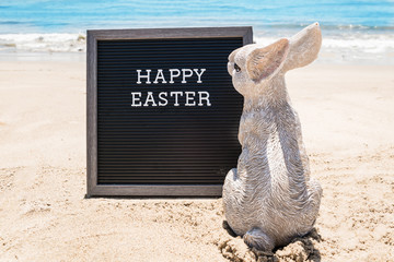 Happy Easter beach background with black board and bunny
