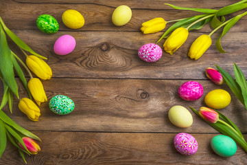Easter rustic background with pink, yellow and green painted eggs