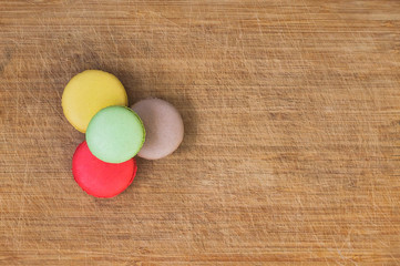 Colorful tasty french macarons isolated on wood texture