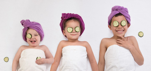 Laughing toddler and kids in bath turbans and towels getting spa treatment
